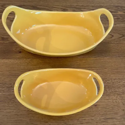 Sale Photo Thumbnail #135: This set features two vibrant yellow ceramic baking dishes from the Rachael Ray collection, ideal for oven, microwave, and dishwasher use. The smaller dish holds 12 oz and measures approximately 8 inches in length and 2.5 inches in height, while the large