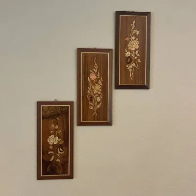 Sale Photo Thumbnail #121: This set of three wall panels features intricate floral inlay designs on rich, dark wooden backgrounds. Each panel showcases unique handcrafted flower motifs detailed in light, natural wood tones, creating a beautiful contrast with the deep brown wood gra