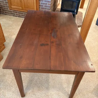 Sale Photo Thumbnail #190: This solid wood dining table features a rich, dark stained finish that highlights the natural grain and character of the wood. Measuring 31 inches tall, 53.5 inches long, and 32.5 inches wide, it offers ample space for family meals or gatherings. The tabl