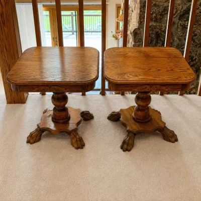 Sale Photo Thumbnail #166: This elegant set of two dark oak pedestal end tables features intricate carved detailing and distinctive claw feet, adding a touch of traditional craftsmanship to any room. Each table stands 20.5 inches tall and measures 22.5 inches in width and depth, of