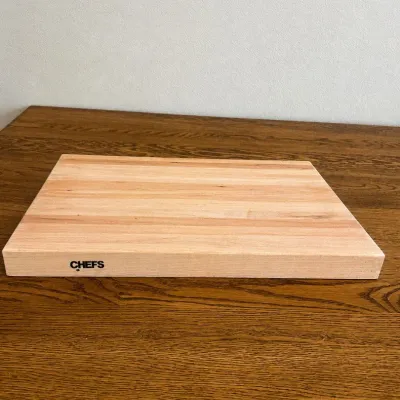 Sale Photo Thumbnail #274: This Chef's Cutting Board features an all-wood construction, offering a sturdy and reliable surface for all your food preparation needs. Crafted from natural wood, it highlights a smooth, polished finish with a light wood tone that complements any kitchen