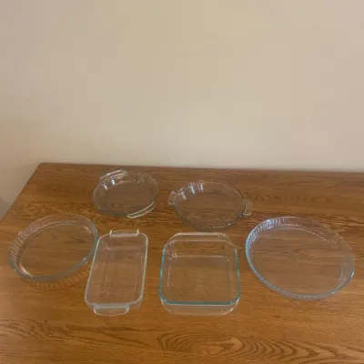 Sale Photo Thumbnail #261: This glass bakeware essentials set includes six versatile pieces perfect for baking, serving, and storing. Crafted from clear, durable glass, the set features a variety of shapes and sizes to accommodate different cooking needs. Dimensions include a recta