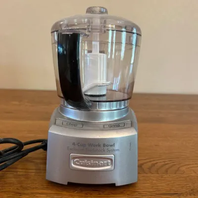 Sale Photo Thumbnail #247: This Cuisinart 4-Cup Food Processor features a compact design with a clear plastic work bowl and a silver base, ideal for small to medium food preparation tasks. The processor includes easy-to-use Chop and Grind functions, perfect for chopping, dicing, an