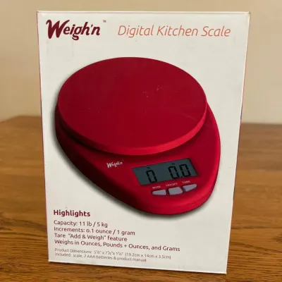 Sale Photo Thumbnail #239: This Weigh'n Digital Kitchen Scale features a vibrant red color and compact design, perfect for precise kitchen measurements. It has a capacity of 11 lb / 5 kg with increments as fine as 0.1 ounce / 1 gram. The scale includes a convenient tare 'Add & Weig
