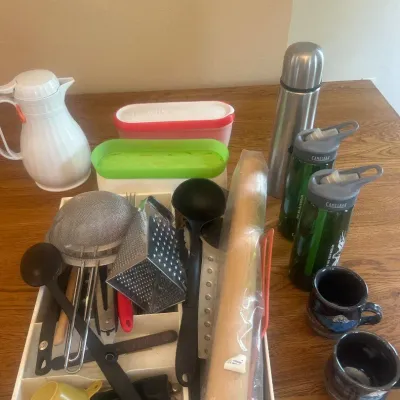 Sale Photo Thumbnail #272: This assorted kitchen essentials set features a variety of practical and useful items perfect for everyday kitchen needs. Included is a white pitcher with an orange lid measuring approximately 9 inches tall, ideal for serving beverages. The set also inclu