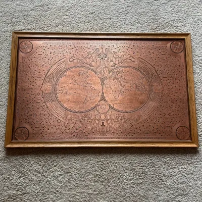 Sale Photo Thumbnail #115: Large decorative world map rendered on what is believed to be copper, featuring two hemispheres surrounded by exceptionally detailed classical figures, scrollwork, celestial imagery, decorative borders, and corner medallions. The intricate design appears 