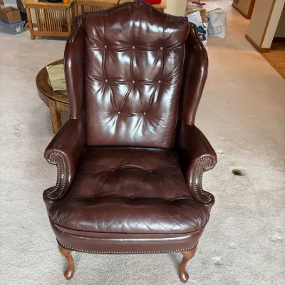 Sale Photo Thumbnail #173: Elegant dark brown tufted leather Chesterfield wingback armchair featuring classic craftsmanship and a comfortable design. This armchair measures 45 inches tall, 31 inches wide, and 28 inches deep, making it an ideal statement piece for any living space. 