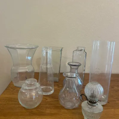 Sale Photo Thumbnail #279: This set features an assortment of decorative glassware pieces, including vases and bottles of varying shapes and sizes. Each piece is made from clear transparent glass, showcasing a sleek and classic design. Notably, one tall cylindrical vase measures ap
