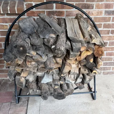 Sale Photo Thumbnail #212: This sturdy firewood rack features a curved metal frame designed to hold a generous amount of firewood. Measuring 53 inches in height and 44 inches in width, it is ideal for organizing and storing logs neatly. The rack comes with a full load of seasoned f
