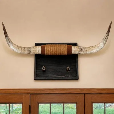 Sale Photo Thumbnail #32: Impressive set of genuine longhorn cattle horns mounted on a substantial rustic wood wall plaque. The horns have a natural cream, gray and brown coloration with darker tips and are wrapped at the center with decorative rope and braided material. The dark-