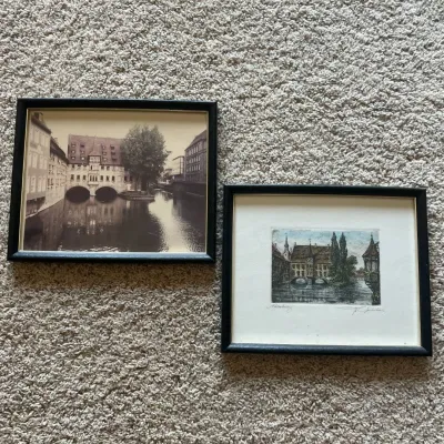 Sale Photo Thumbnail #87: Pair of vintage framed German city views depicting Nürnberg (Nuremberg), Germany, including the historic Heilig-Geist-Spital spanning the Pegnitz River.

The smaller artwork is a hand-colored etching, pencil titled “Nürnberg” at lower left and penci