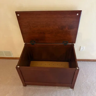Sale Photo Thumbnail #75: This wooden toy chest is designed for the main bedroom, crafted from high-quality wood with a rich mahogany finish. It features a spacious interior with dimensions of 21 inches tall, 34 inches wide, and 21 inches deep, providing ample storage for toys or 