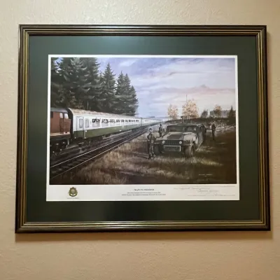 Sale Photo Thumbnail #42: Framed limited-edition military print by George Finley, titled “Train to Freedom.” The work commemorates East German refugees reaching West Germany in October 1989 and features members of the 2d Armored Cavalry Regiment alongside the refugee train.

T