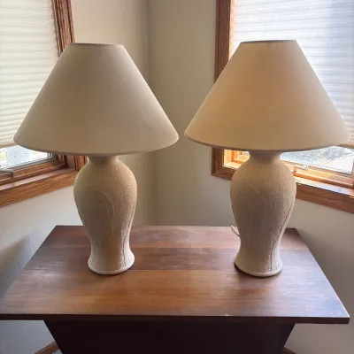 Sale Photo Thumbnail #172: This elegant pair of ceramic lamps features a textured surface with an embossed leaf motif, adding a natural and artistic touch to any room. Each lamp stands 28.5 inches tall and is complemented by a 19-inch wide flared fabric shade that softly diffuses l