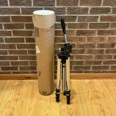 Sale Photo Thumbnail #222: This Manon #800 tripod is a sturdy and adjustable support designed for cameras and other equipment. Crafted from lightweight aluminum, it features extendable legs with secure locks and a smooth, easy-to-operate pan-and-tilt head with a comfortable handle.