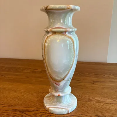 Sale Photo Thumbnail #28: This exquisite hand-carved vase is made from green and honey onyx marble, showcasing beautiful natural veining and color variations. Standing 15.5 inches tall and 6 inches wide, this vase features a classic shape with elegant curves and a flared rim, perf