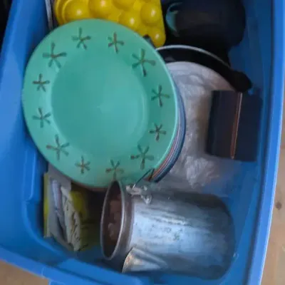 Collection of camping and outdoor gear stored inside a blue plastic tote