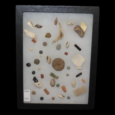 Sale Photo Thumbnail #251: Amazing frame of Mimbres / Hohokam Drilled Stone, Clay, & Shell Beads, Pendants, & Gorgets. Part of a shell bracelet, effigy piece off of a black & white pottery vessel, etc. Great group of relics!