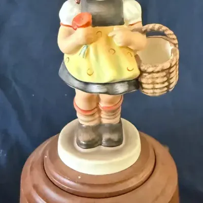 Title: Goebel Hummel “Sister” #98 Girl with Basket on Wooden Music Box Base
