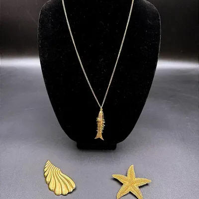 A Monet Starfish Pin, A Gold-toned Shell Brooch & An Articulated Fish Pendant Necklace