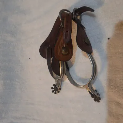 western riding spurs with brown tooled-leather spur straps