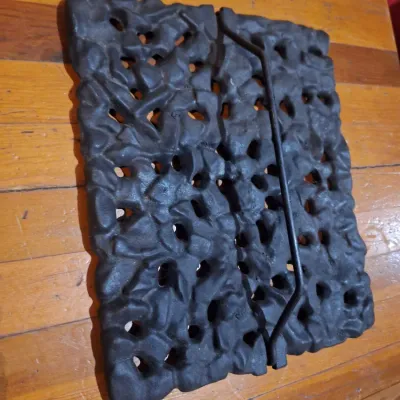 cast iron piece with open scroll work and handles.