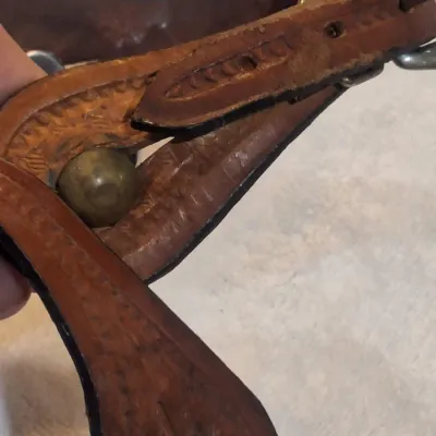 western riding spurs with brown tooled-leather spur straps