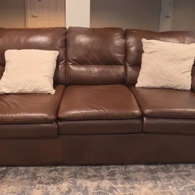 Brown Leather Couch W/ 2 White Throw Pillows
