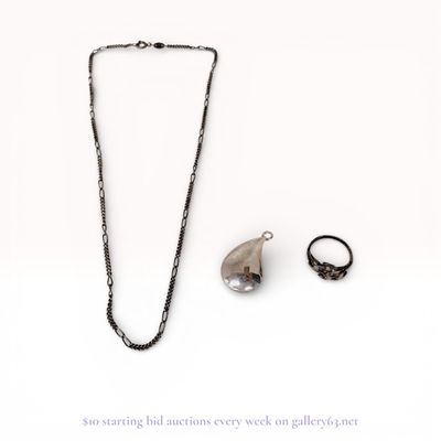 A Trio of Silver and Silver-Tone Jewelry Including a Figaro Chain, Teardrop Pendant, and Figural Bird Ring