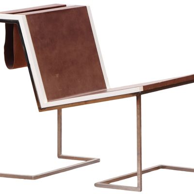 A BAUHAUS INSPIRED LEATHER AND STAINLESS STEEL CHAIR WITH A SLING COMPARTMENT FOR MAGAZINES.