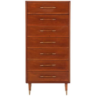 A WOOD AND BRASS TALL CHEST OF DRAWERS HAVING ELONGATED HANDLES IN THE MANNER OF T.H.