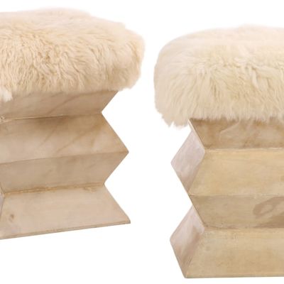 A PAIR OF PARCHMENT COVERED STOOLS UPHOLSTERED IN FAUX FUR.