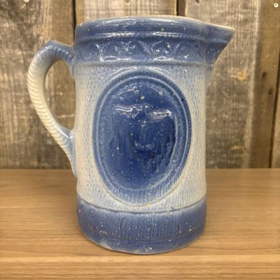 Sale Photo Thumbnail #448: A.E. Hull Blue and White Salt Glaze Stoneware Milk Pitcher with Cow Motif