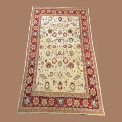 Classic Ivory Floral Area Rug – A light neutral field with red and green floral details and a traditional decorative border.