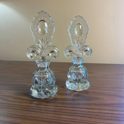 p air of Clear Glass Perfume Bottles with Ornate Fleur-de-lis Shaped Stoppers.jpg