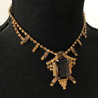 Beautiful vintage, mid-century, large emerald, cut smoky topaz or amber colored center rhinestone accented with yellow and topaz colored...