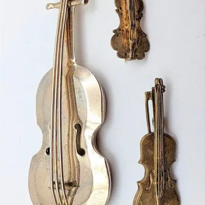 Sale Photo Thumbnail #88: Collection of Three Stringed Instrument Brooches Including One Sterling Marked Met. Museum of Art