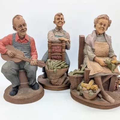 Sale Photo Thumbnail #300: Three Tom Clark Figures | 2002 Wilmer with Guitar | Leah 1986 Shucking Corn | Jacob 1986 with Corn