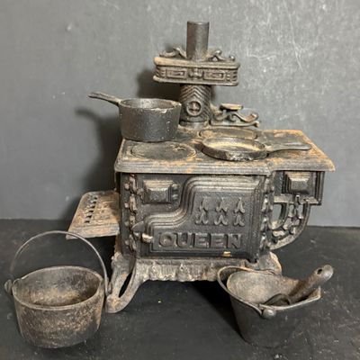 LOT 81: Vintage/Antique Queen Cast Iron Stove with Pot and Pans and Star Toy Stove