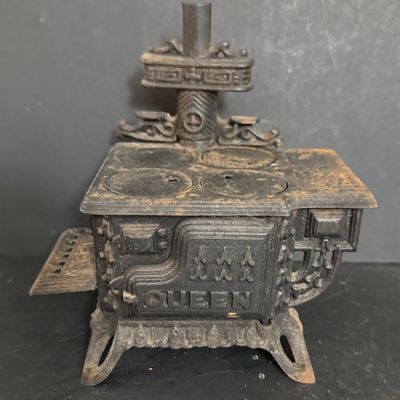 LOT 81: Vintage/Antique Queen Cast Iron Stove with Pot and Pans and Star Toy Stove