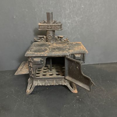 LOT 81: Vintage/Antique Queen Cast Iron Stove with Pot and Pans and Star Toy Stove