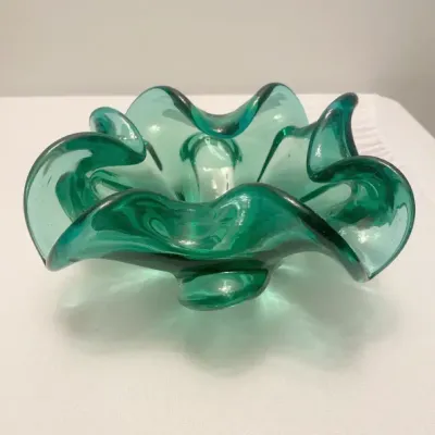 Vintage green Murano style glass bowl features a distinct rolled edge and organic flower shape.