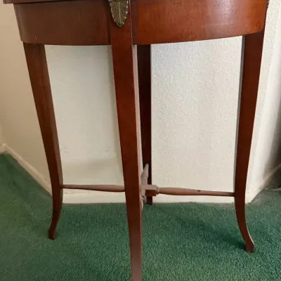 Elegant vintage demilune console table featuring a half-moon top, warm mahogany-tone finish, slender