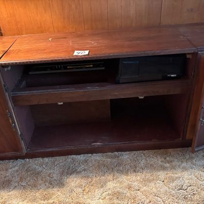 This vintage mid-century modern wooden stereo console features an integrated AM/FM radio and a top-loading record player turntable
