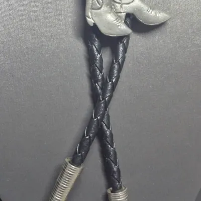 Sale Photo Thumbnail #230: Vintage from before 2007
Materials: fabric, Silver Tone Metal

Vintage Western Cowboy Boots Bolo Tie Silver Tone Retro Cowboy Neck Tie Western Fashion New Old Stock
Nice Silver tone metal Cowboy Boots Bolo Tie with Fabric Cord.
Great western Motif!
Measur
