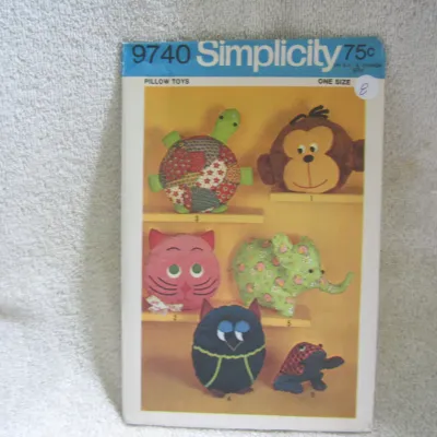 Sale Photo Thumbnail #9: Vintage Simplicity sewing pattern number 9740 for 'Pillow Toys'. This one-size pattern includes designs to make various stuffed animal pillows, including a turtle, monkey, cat, elephant, owl, and frog. The envelope shows light wear and minor age-related d