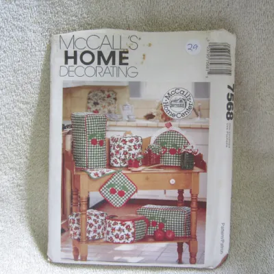 Sale Photo Thumbnail #30: Vintage McCall's Home Decorating sewing pattern number 7568. Includes patterns for kitchen appliance covers, potholders, jar toppers, and other kitchen accessories featuring a cherry and gingham theme. The paper envelope shows some wear, including light s