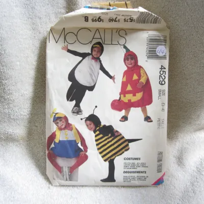 Sale Photo Thumbnail #45: Vintage McCall's sewing pattern number 4529 for children's costumes. Features designs for a Jack-O-Lantern, Bumble Bee, Humpty Dumpty, Mouse, Bunny, Penguin, and Ice Cream Sundae. Size Small (3-4). The paper envelope shows some wear, creasing, and minor t