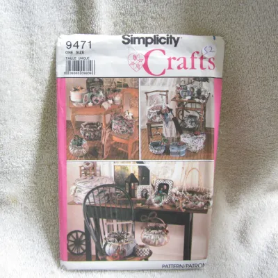 Sale Photo Thumbnail #53: Vintage Simplicity Crafts sewing pattern number 9471. One size. Features patterns and instructions for various fabric-covered home decor items including baskets, boxes, and picture frames. The envelope shows some light wear, creasing, and a handwritten pr