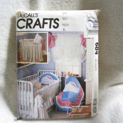 Sale Photo Thumbnail #37: Vintage McCall's Crafts sewing pattern number 684, titled 'The New Arrival'. This pattern features designs to decorate an infant's room with a bunny theme, including a crib comforter, bumper pad, dust ruffle, diaper stacker, wall hanging, and window treat